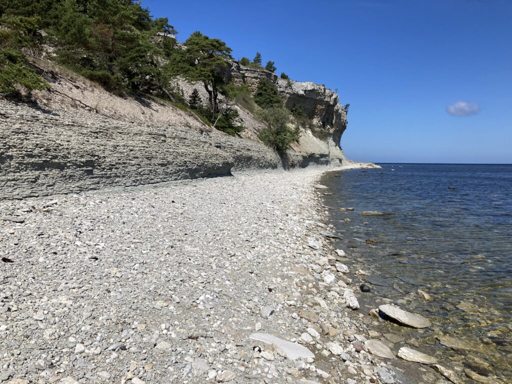 Fotografi av stenkust på Gotland, med branta slänter ned mot havet.